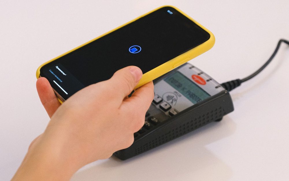 Un cliente acercando el móvil a una placa NFC