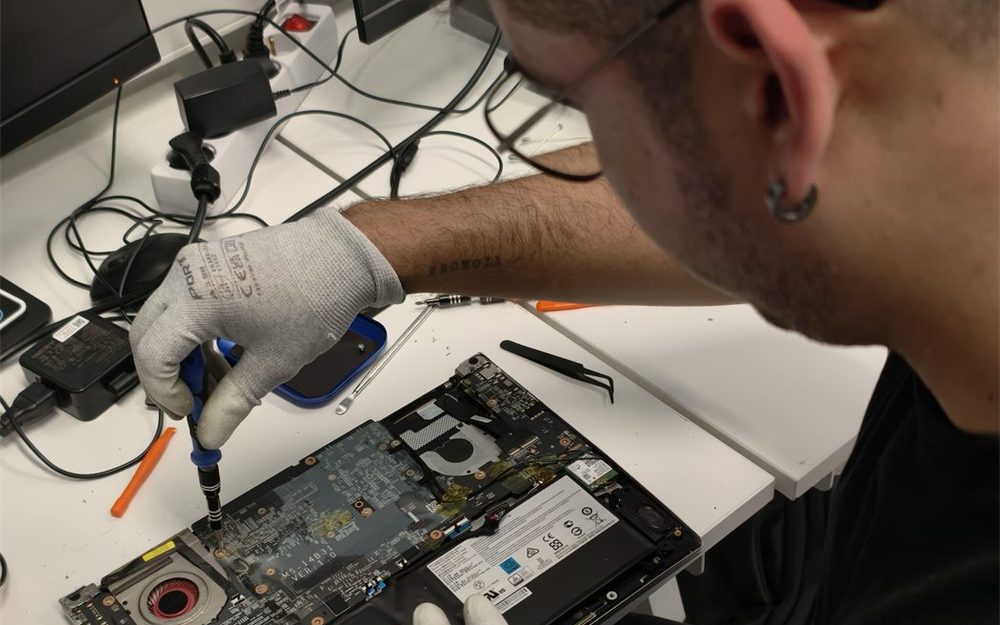 Técnico de TecnoSoluciones reparando un portátil